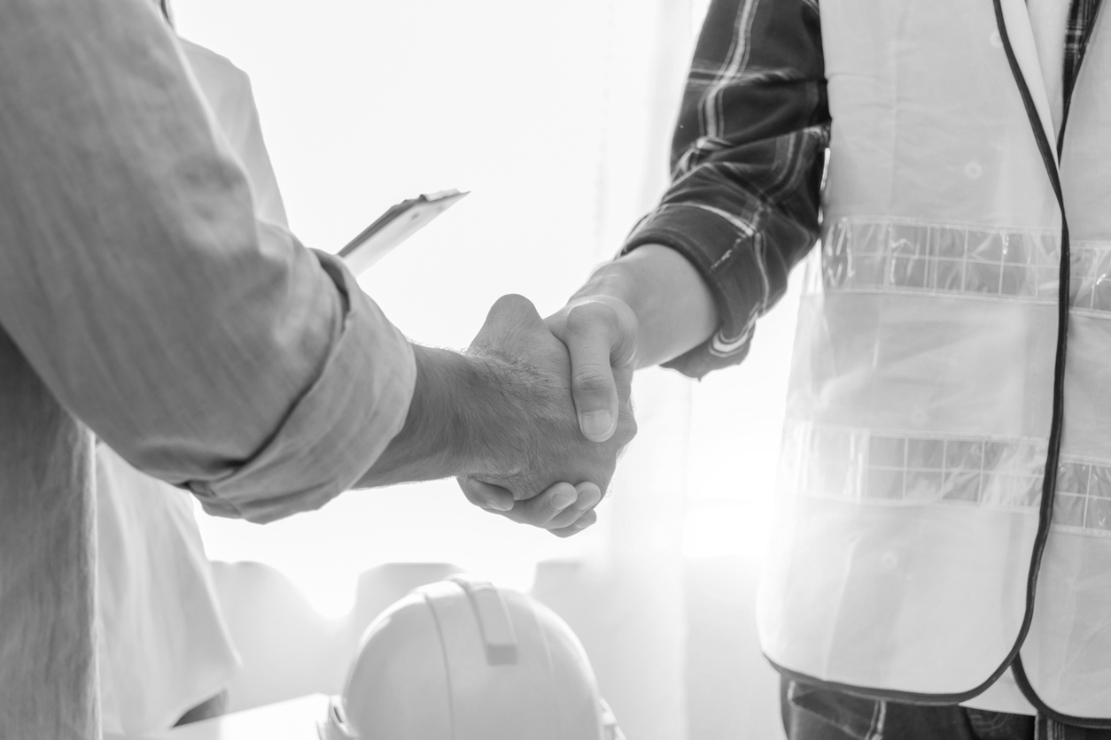 Contractor. construction worker team hands shaking after plan project contract on workplace desk in meeting room office at construction site, contractor, engineering, partnership, construction concept