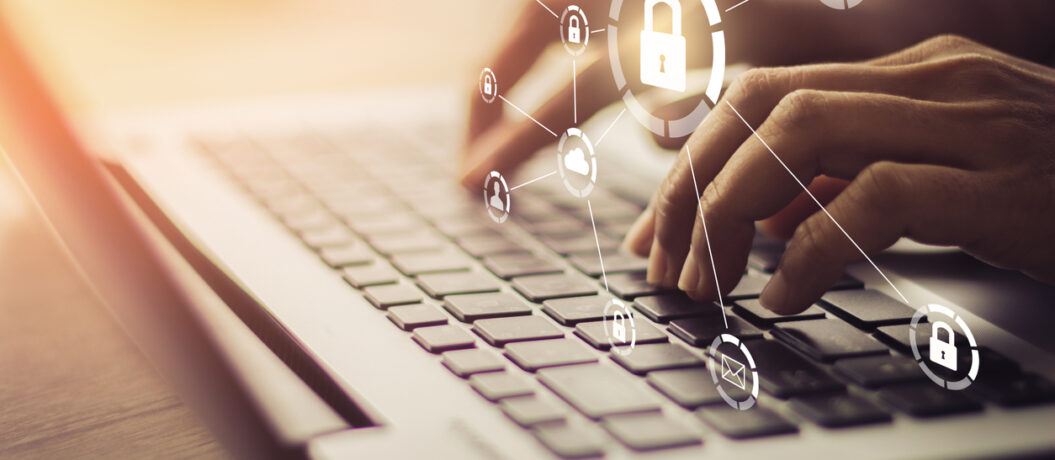 Business, technology, internet and networking concept. Young businesswoman working on his laptop in the office, select the icon security on the virtual display.