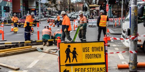 Melbourne, Victoria, Australia, September 8, 2018: Many road workers in orange vests are working on a busy inner city street.