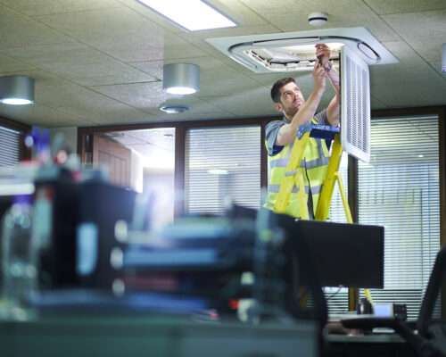 air con maintenance engineer in empty office floor
