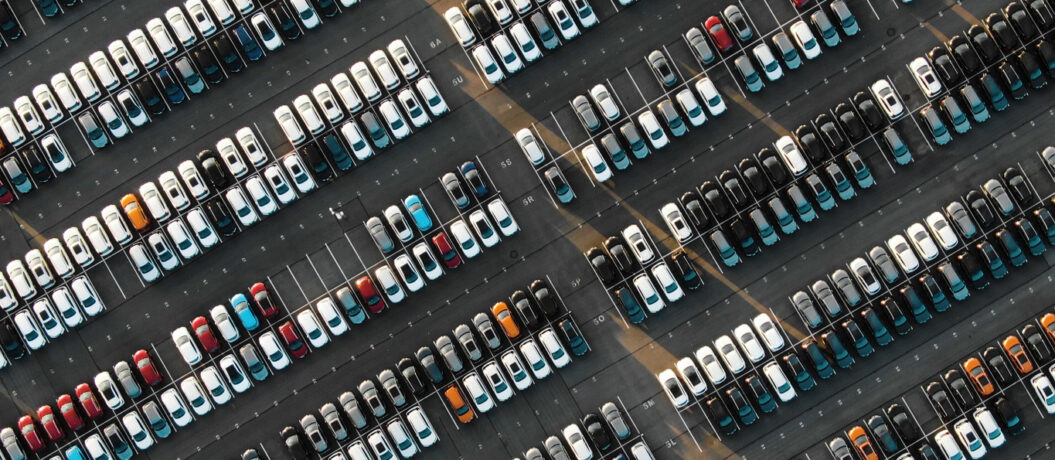 fantastic flight over parked new cars at the car building enterprise at sunset, smooth rows of cars