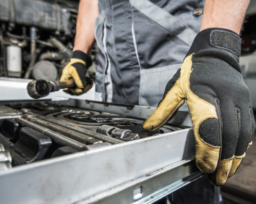 Caucasian Mechanic Selecting Right Tools For the Repair Job. Professional Garage Tools. Automotive Industry Theme.