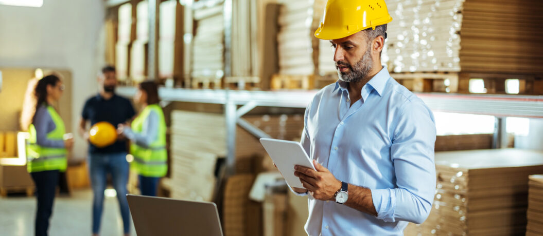Warehouse manager working process checking the package with a tablet in a large distribution center
