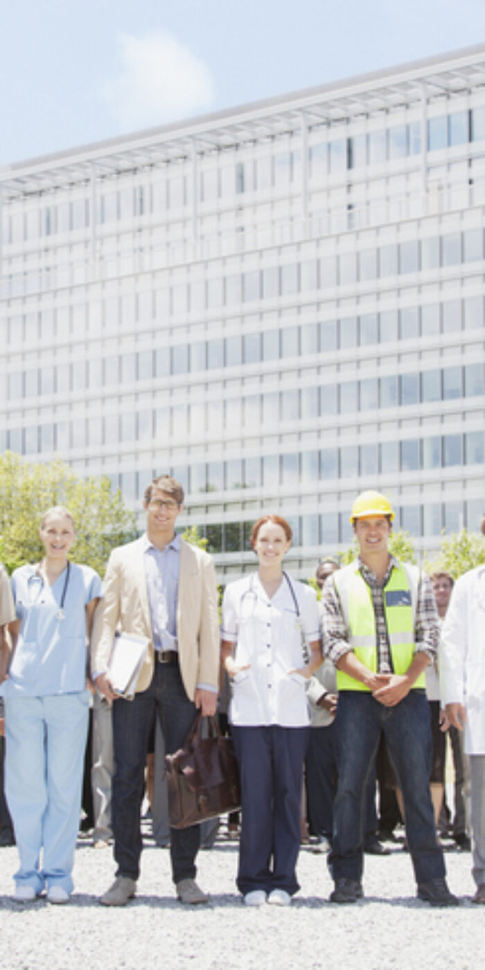 Portrait of professionals and workers with crowd of business people in background