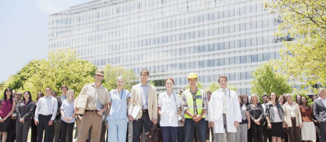 Portrait of professionals and workers with crowd of business people in background