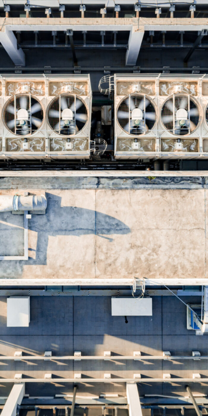 Aerial top down view of ventilation and air conditioning systems installed on the rooftop of a skyscraper in a developed business district