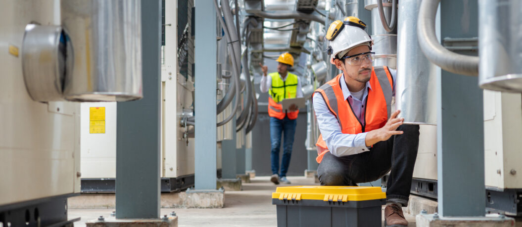 Engineer under checking the industry chilled water fan coil unit air conditioner is water cooling tower air chiller HVAC system of large industrial building to control air system