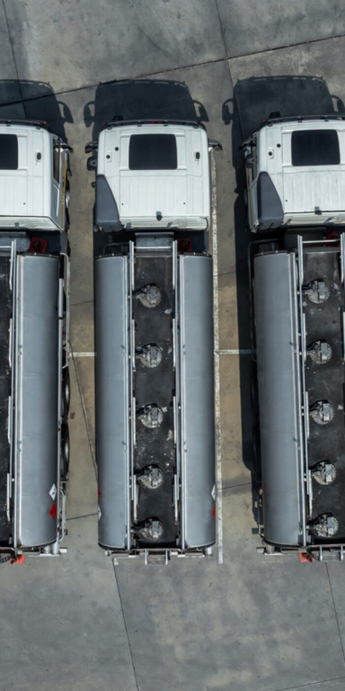 Fuel truck park on parking lot, Business oil and gas transportation and logistics with petrochemicals liquid chemical freight, Fuel tank truck transports fuel, Aerial view.