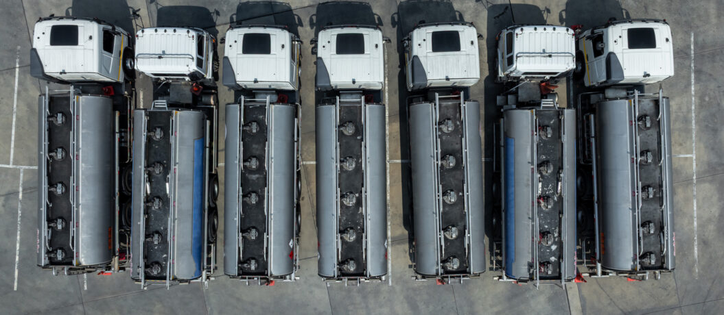 Fuel truck park on parking lot, Business oil and gas transportation and logistics with petrochemicals liquid chemical freight, Fuel tank truck transports fuel, Aerial view.