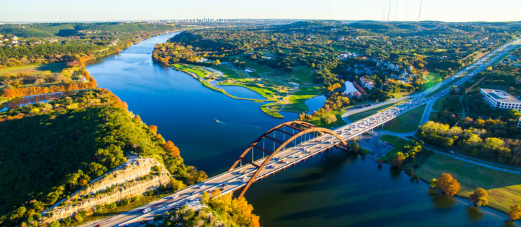Aerial Pennybacker Bridge 360 Bridge From the Air as the leaves change colors and fall and the seasons change in central Texas. Fall turns to winter and Austin , Texas glows with bright colors of Fall and green and the Texas hill country looks amazing. This aerial breathtaking image of the Pennybacker Bridge built in 1984 and completes the Austin Vibe of West Texas Hill Country