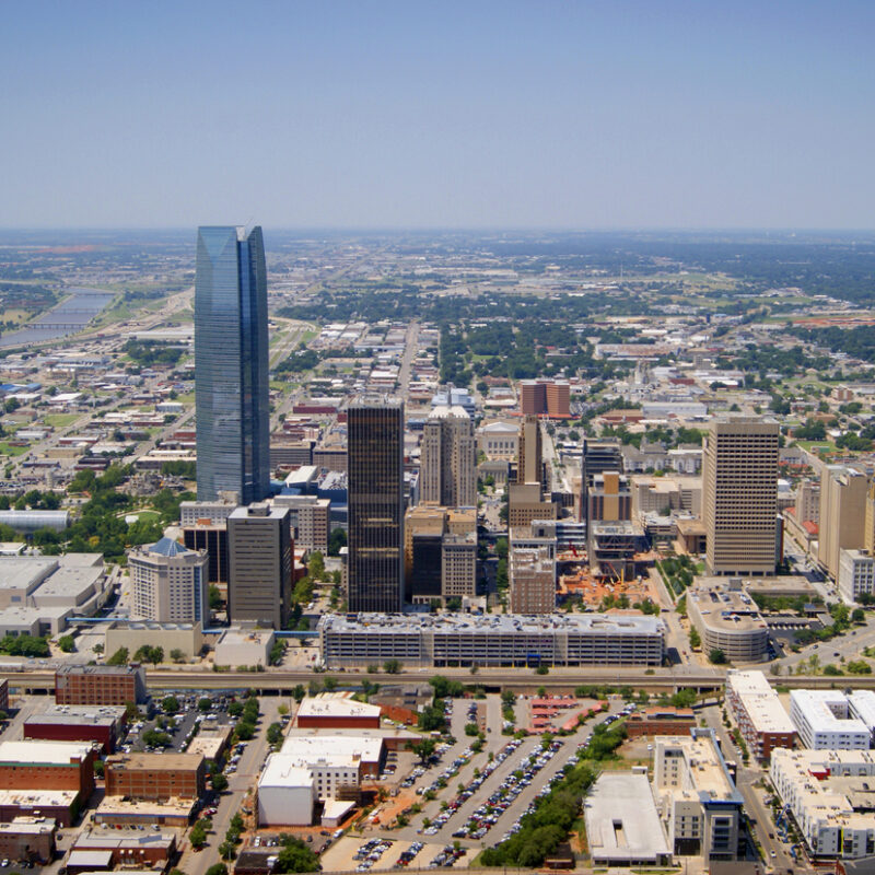 The aerial view of Oklahoma City, Oklahoma taken from a Robinson 44 helicopter with the door removed on August 15, 2014. Oklahoma City is the capital and largest city of the state of Oklahoma. The city ranks as the eighth-largest city in the United States by land area.