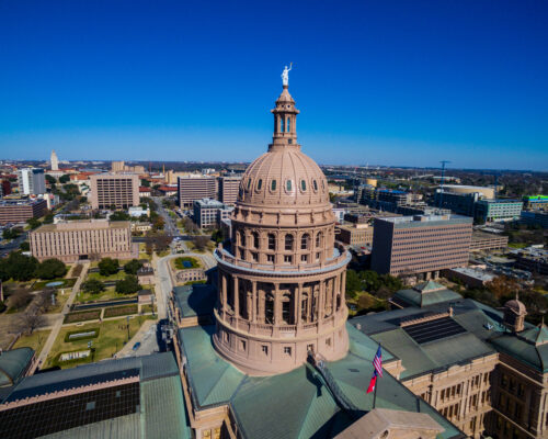 Texas State Capitol Building Over Austin Texas with American and Texas Flag flying above the Governmental Capitol building