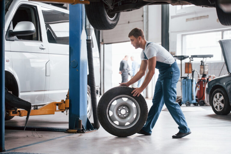man changing tire in maintenance shop