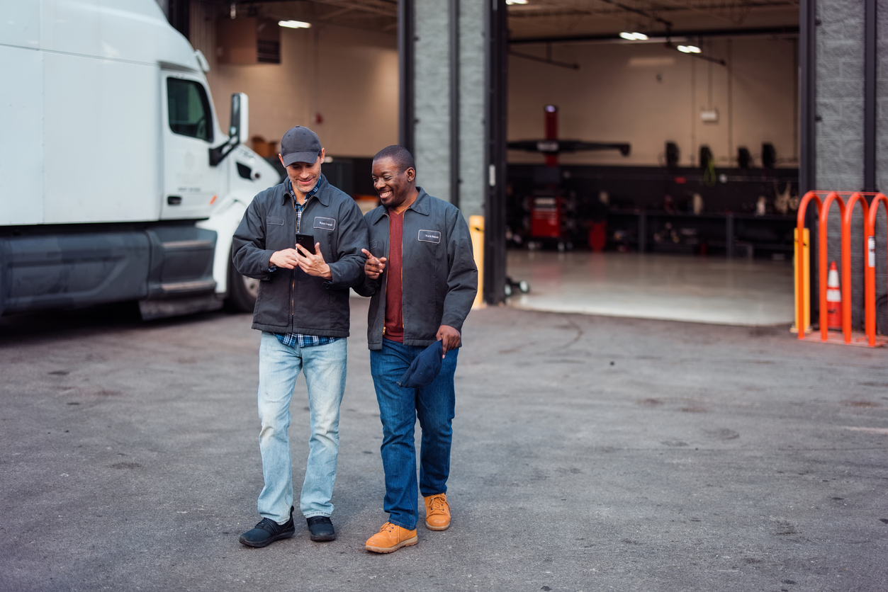 Two Mechanics Sharing a Moment Outside an Auto Repair Garage