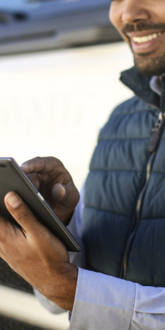 Truck driver using a tablet. About 35 years old, African male.
