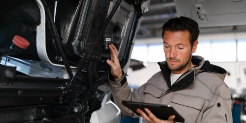 Truck mechanic is checking safety of truck.