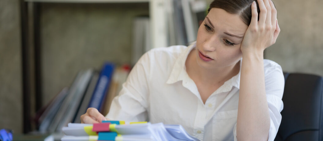women stressed over paperwork at desk